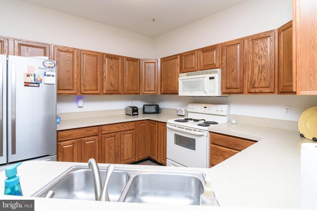 4101D Fullerton Ct, Milford, DE 19963 - kitchen with brown cabinetry, white appliances, light countertops, and a sink