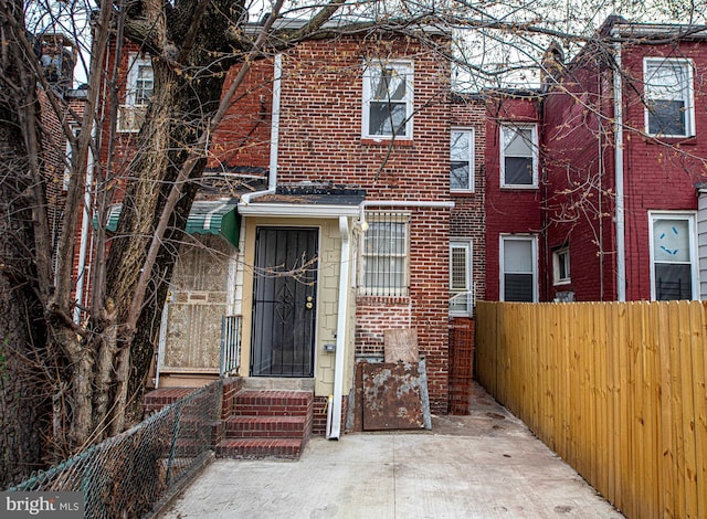 townhome / multi-family property featuring brick siding and fence