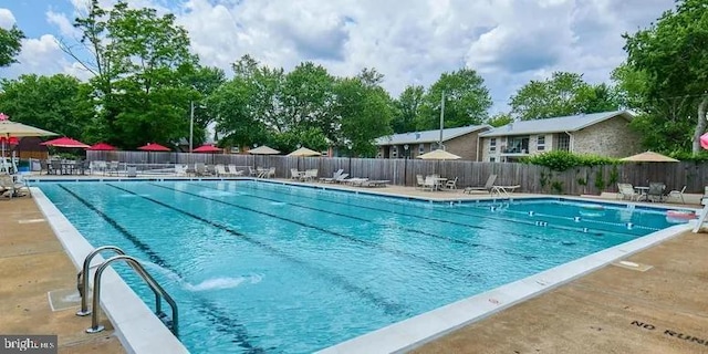 community pool with fence and a patio area