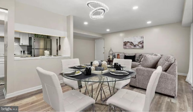 dining room with recessed lighting, light wood-type flooring, a chandelier, and baseboards