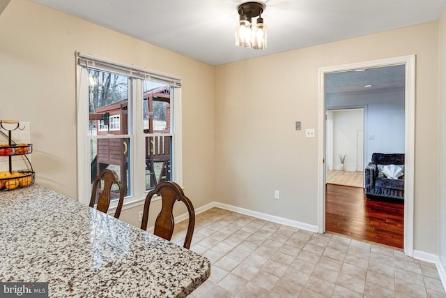 dining space featuring light tile patterned floors, a ceiling fan, and baseboards