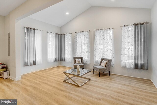 sitting room with vaulted ceiling, wood finished floors, and a wealth of natural light