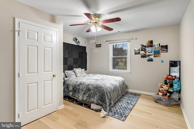 bedroom with baseboards, wood finished floors, and a ceiling fan