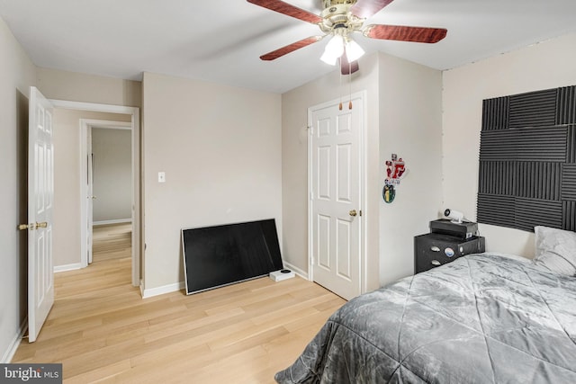 bedroom featuring a ceiling fan, baseboards, and wood finished floors