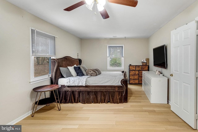 bedroom featuring a ceiling fan, light wood-style floors, and baseboards