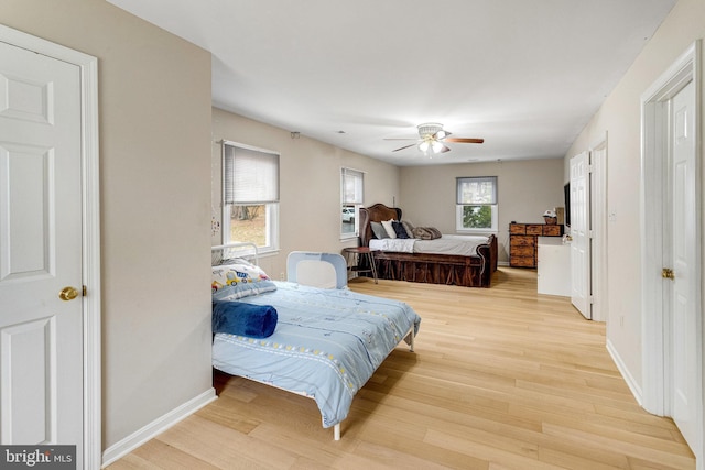 bedroom with ceiling fan, baseboards, and wood finished floors