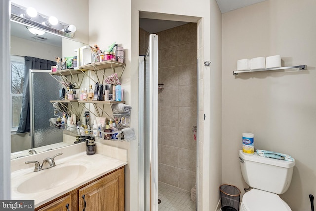 bathroom featuring vanity, toilet, and a stall shower