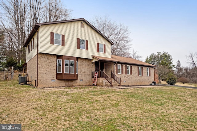 view of front facade with crawl space, brick siding, central AC, and a front yard