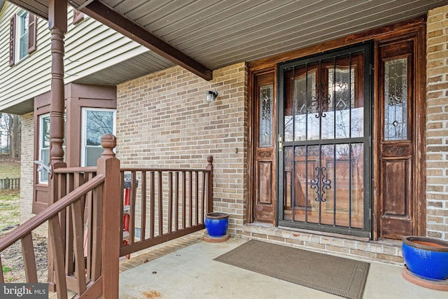 entrance to property featuring brick siding