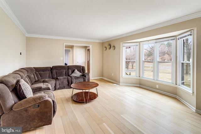 living area with light wood-type flooring, baseboards, and ornamental molding