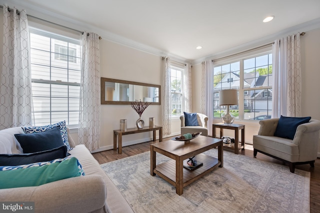 living area featuring baseboards, recessed lighting, wood finished floors, and crown molding