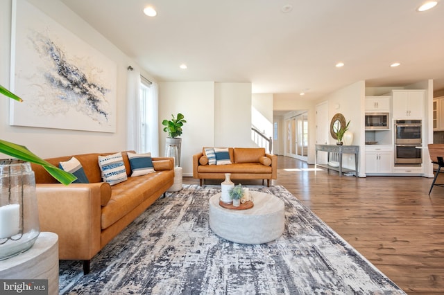 living room featuring baseboards, recessed lighting, wood finished floors, and stairway