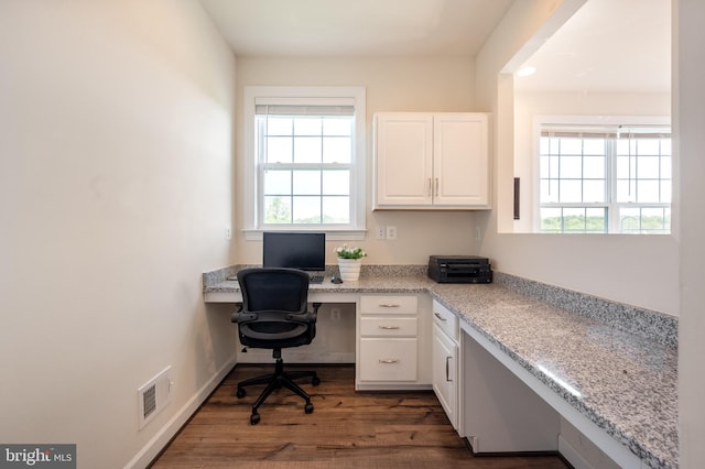 office space with visible vents, wood finished floors, and built in study area