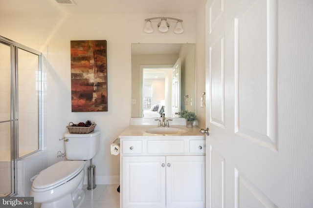 ensuite bathroom featuring connected bathroom, toilet, vanity, tile patterned flooring, and tiled shower