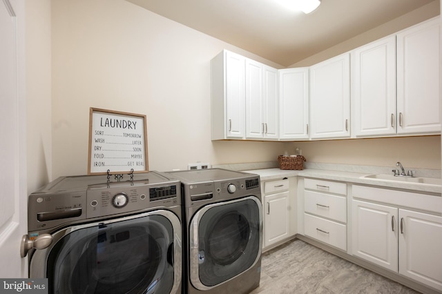 laundry room with washer and dryer, cabinet space, and a sink