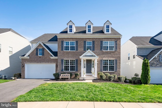 view of front of home with a garage, brick siding, aphalt driveway, and a front yard