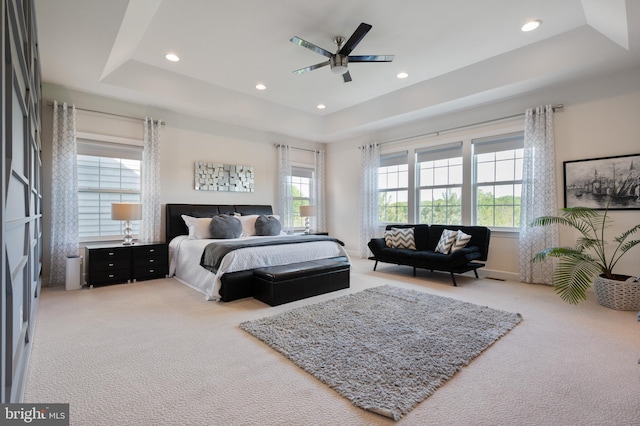 bedroom featuring recessed lighting, ceiling fan, light colored carpet, and a tray ceiling
