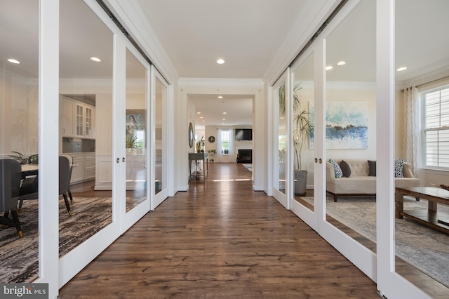 corridor featuring french doors, ornamental molding, and dark wood finished floors