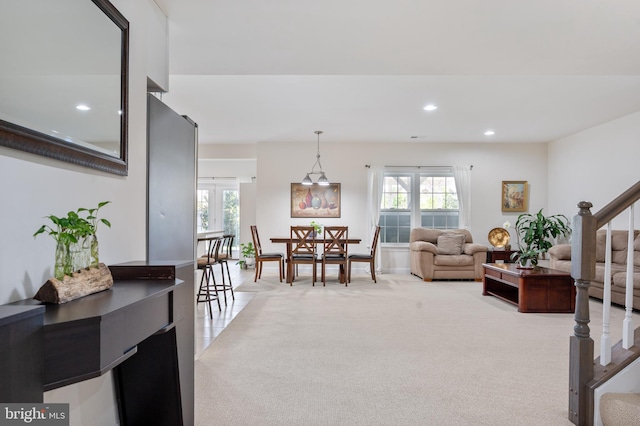 living area featuring stairway, light carpet, a healthy amount of sunlight, and recessed lighting