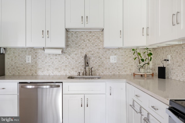 kitchen featuring white cabinetry, light countertops, stainless steel dishwasher, and a sink