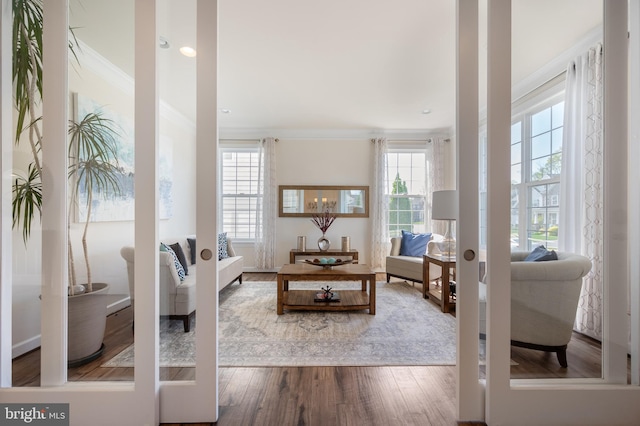 living room with wood finished floors and crown molding