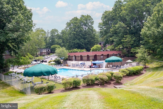community pool featuring a patio, a yard, and fence