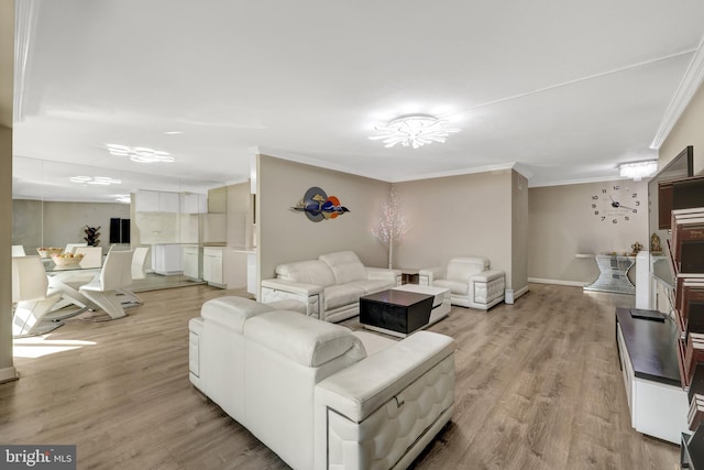 living room with light wood-type flooring, baseboards, and crown molding