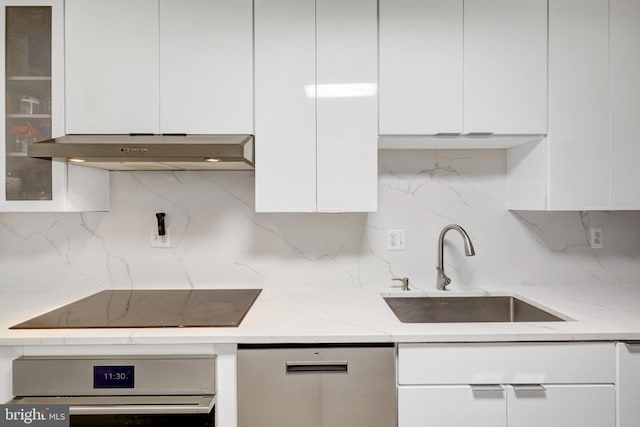 kitchen with oven, under cabinet range hood, a sink, black electric cooktop, and dishwasher