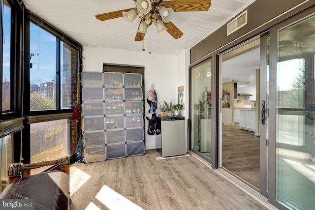 unfurnished sunroom with visible vents and a ceiling fan