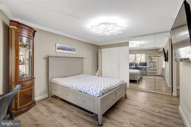 bedroom featuring baseboards, ornamental molding, and light wood finished floors