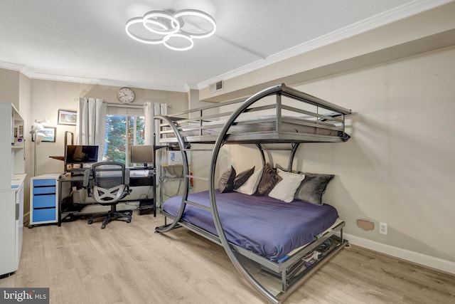 bedroom featuring visible vents, baseboards, wood finished floors, and ornamental molding