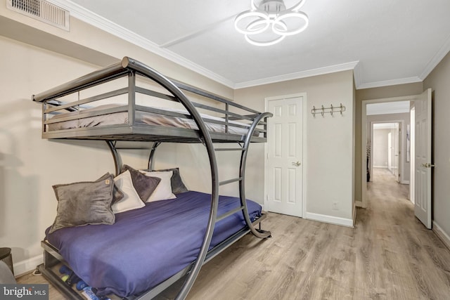 bedroom featuring wood finished floors, visible vents, baseboards, crown molding, and a notable chandelier