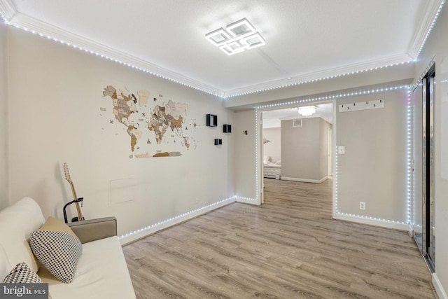 interior space featuring baseboards, wood finished floors, and crown molding