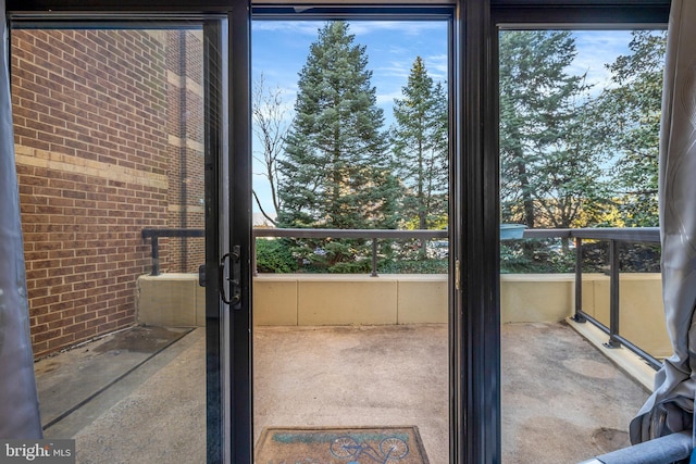 doorway featuring brick wall and concrete flooring