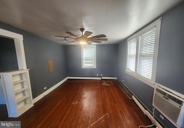 unfurnished room with ceiling fan, baseboards, and wood finished floors