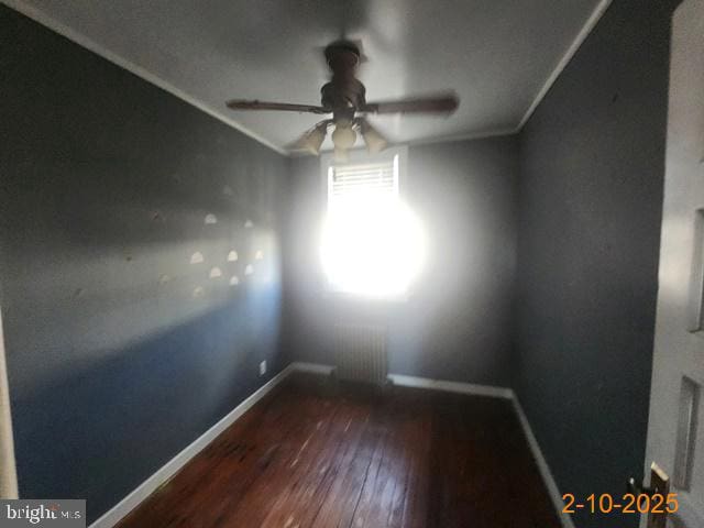 empty room with visible vents, crown molding, baseboards, ceiling fan, and wood finished floors