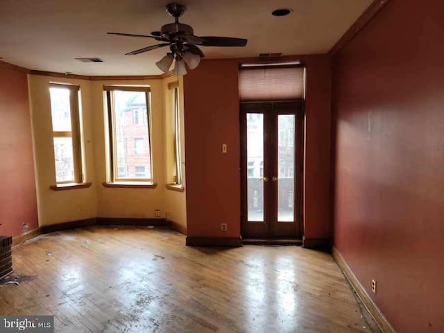 foyer with a wealth of natural light, baseboards, crown molding, and ceiling fan