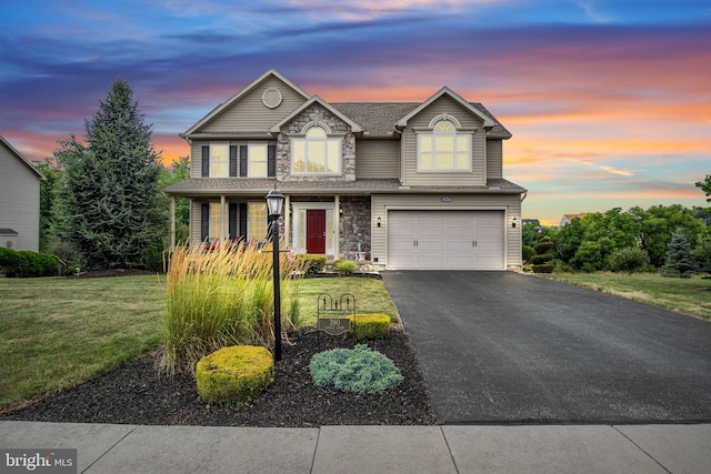 traditional home featuring aphalt driveway, an attached garage, stone siding, and a yard