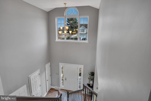 entrance foyer featuring high vaulted ceiling, wood finished floors, visible vents, and baseboards