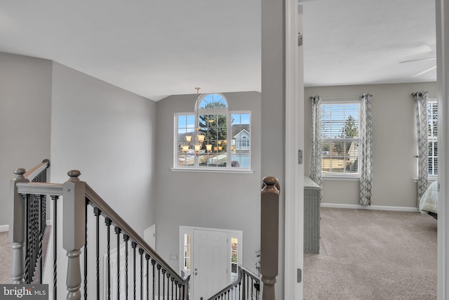 interior space with baseboards, carpet floors, a notable chandelier, and lofted ceiling