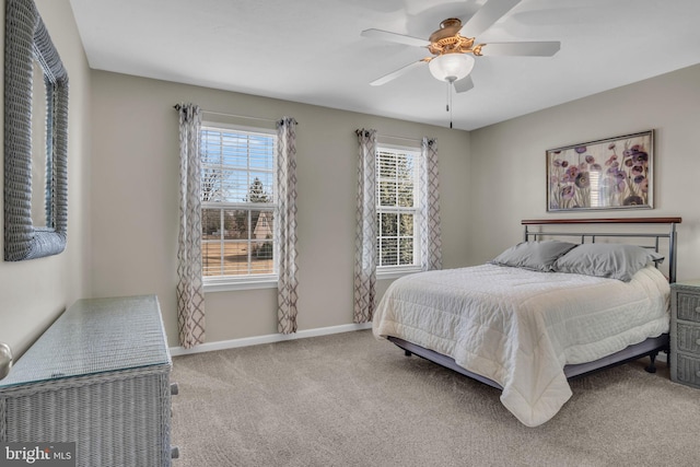 carpeted bedroom with baseboards, multiple windows, and a ceiling fan