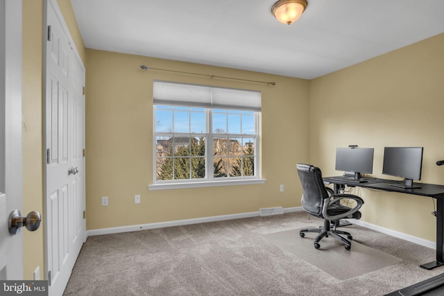 carpeted office space featuring visible vents and baseboards