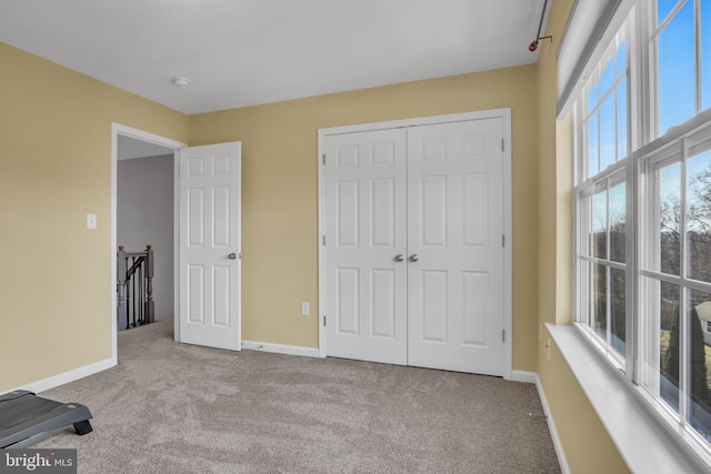 unfurnished bedroom with a closet, baseboards, and carpet