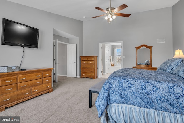 bedroom featuring visible vents, ceiling fan, light colored carpet, ensuite bathroom, and high vaulted ceiling