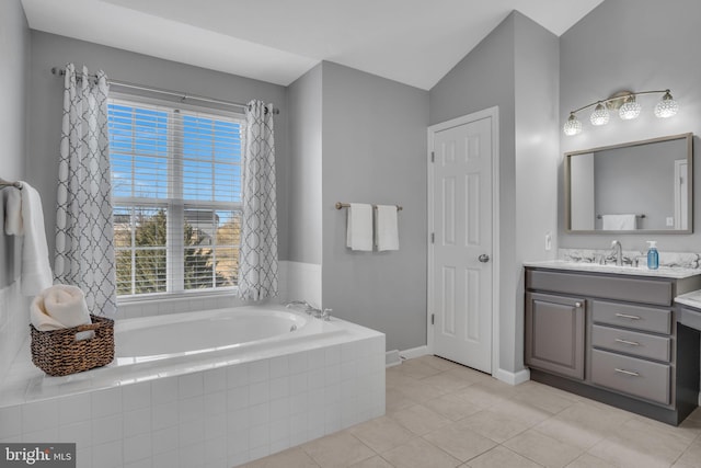 bathroom with vanity, baseboards, lofted ceiling, tile patterned flooring, and a bath