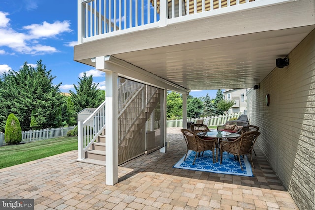 view of patio / terrace featuring stairs, outdoor dining area, and fence