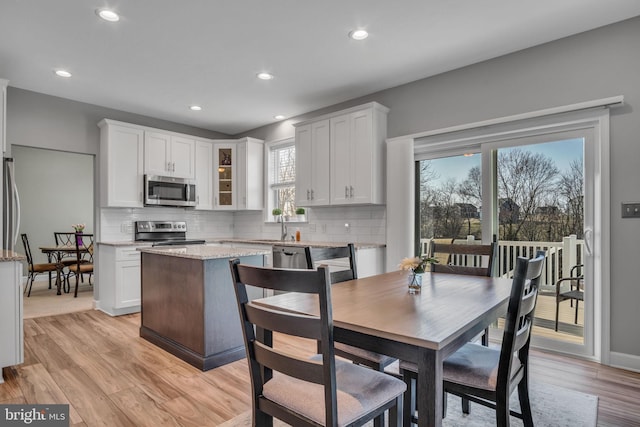 dining space with recessed lighting, light wood-style floors, and baseboards