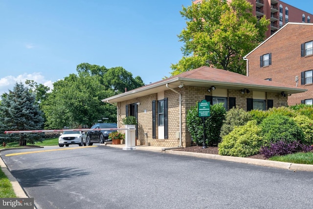 exterior space with uncovered parking and brick siding