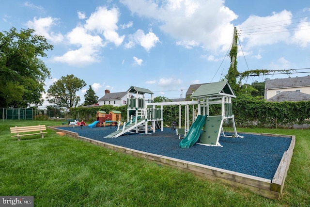 community jungle gym featuring a lawn and fence