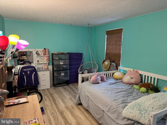 bedroom featuring a textured ceiling and wood finished floors